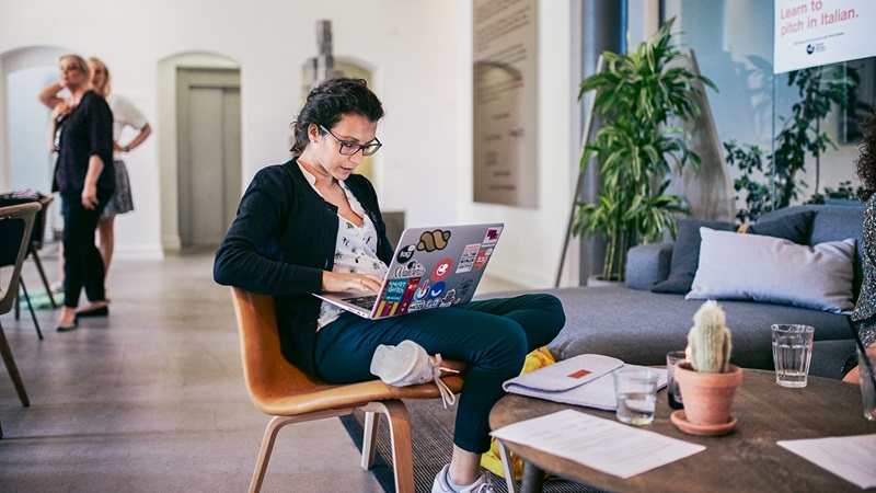 Woman sitting in office space working on a laptop