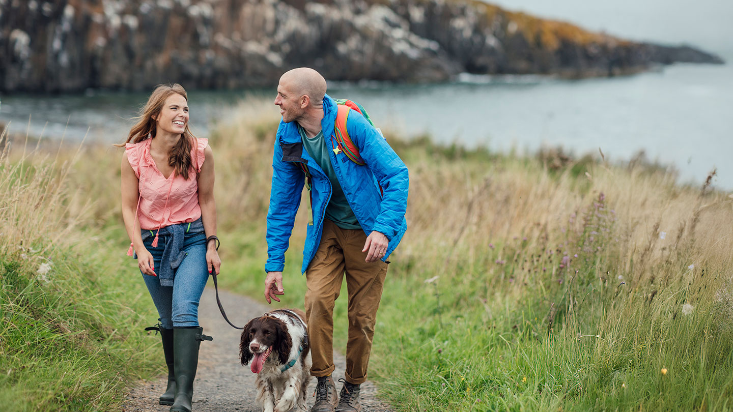 Happy couple walking dog Happy couple walking dog