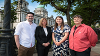 Danske Bank secures a spot on Stonewall’s Top 100 Employers Four people stand outside, with Belfast City Hall in the background. They're all smiling at the camera.