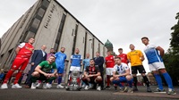 Danske Bank Premiership 2022-23 launch Fourteen people standing outside in front of Danske Bank headquarters. The Danske Bank Premiership trophy is sitting in front of them. Tweleve are players in full kits.